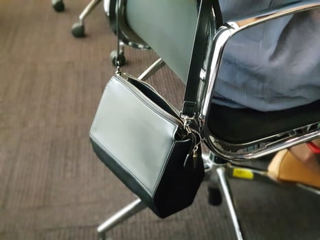 A person sitting on a chair with a purse photo