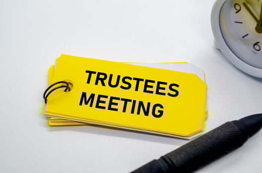 Trustees Meeting notepad with keyring on yellow background. photo