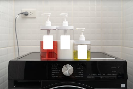 Set of colorful liquid detergent bottles with pump on washing machine for laundry cleaning household chores photo