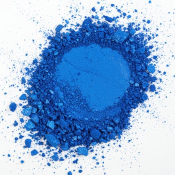Vibrant blue pigment powder scattered and crushed on a white background photo