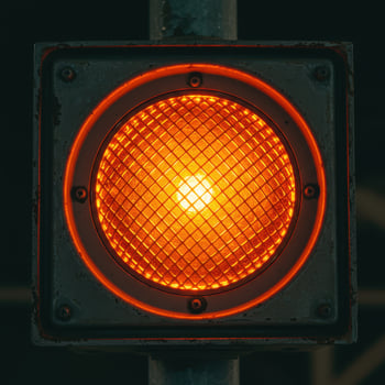 Close up of a single glowing orange traffic signal light with a textured lens photo