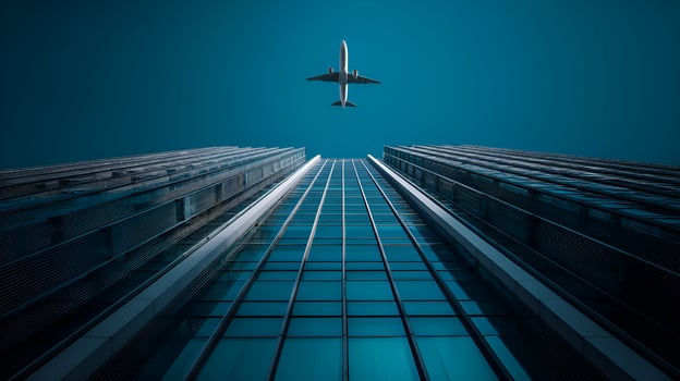 Airplane flying over modern skyscrapers in a clear blue sky photo