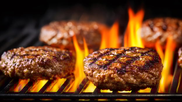 Delicious grilled hamburgers cooking on a hot flaming bbq grill photo