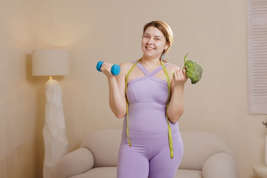 Happy Plus Size Woman with Dumbbell and Broccoli Fitness Weight Loss Healthy Eating and Sports Concept photo