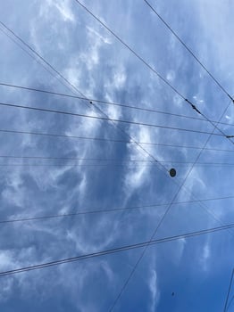 Dramatic Clouds Interwoven with Cables Form an Artistic Contrast Against a Clear Blue Sky photo