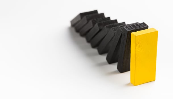 Smart business management. Domino effect stopped by unique strong piece, white panorama background with free space photo