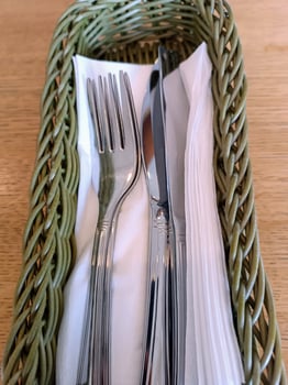 utensils on table in basket with napkins restaurant cafe cozy home serving waiter meal dinner photo
