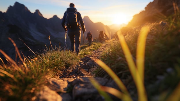 Hikers hiking in the mountains at sunset photo