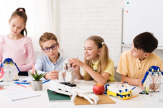 Excited children creating robots together, studying in classsroom, stem education concept photo