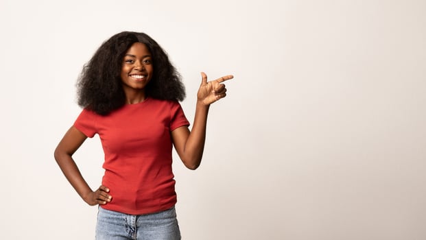 Place For Ad. Happy Black Lady Pointing Aside At Copy Space With Finger, Cheerful African American Woman Recommending Nice Offer While Standing Isolated Over White Studio Background, Panorama photo