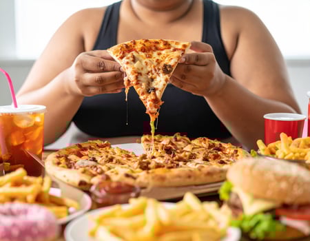 A woman is eating a pizza with a soda photo