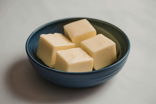 A photograph of four pristine cubes of pale yellow butter photo
