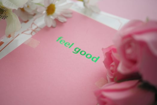 Bright pink card with feel good message and flowers nearby photo