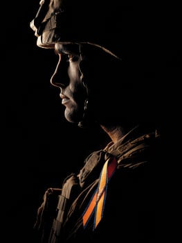 Soldier Silhouette in Shadows Highlighting Support Ribbon During Emotional Tribute photo