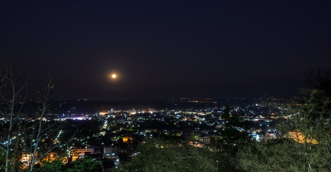 City skyline at night with moon photo