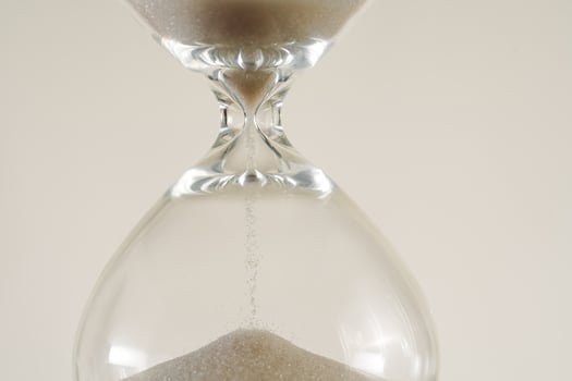 A minimalist conceptual image of an hourglass to symbolize the passage of time, aging, and importance of skincare, balance. photo