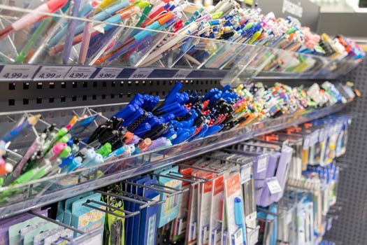Wide array of colorful pens, pencils, and diverse stationery supplies organized on retail shelves, offering school and office essentials for purchase photo