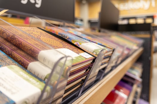 Abundant selection of vibrant, decorative notebooks neatly displayed on a retail store shelf, providing essential stationery for educational and professional use photo