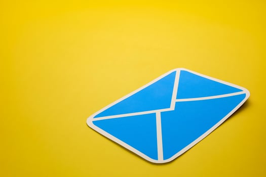 Paper letter on yellow background, with copy space. Business concepts of online contact channels, electronic mail inbox notifications, and sending and receiving documents using online networks. photo
