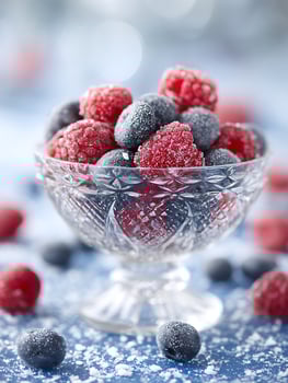 Frozen Raspberries and Blueberries in Crystal Bowl, Close Up. photo