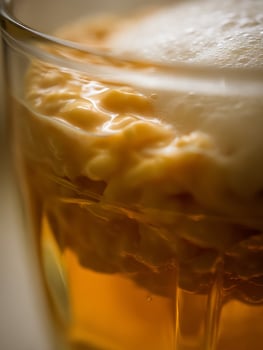 Close up of a Glass of Creamy, Golden Beer with a Thick Head. photo