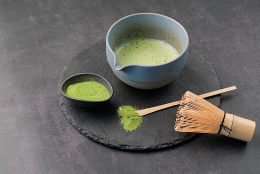 Traditional green matcha kit, Bamboo whisk and beverage on slate plate photo