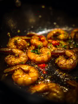 Close Up of Delicious Sauteed Shrimp with Chili Peppers and Herbs in a Pan. photo