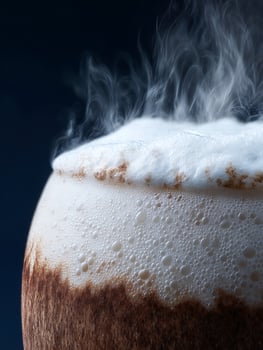 Close up of Steaming Mug of Dark Beer with Creamy Head. photo