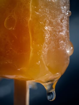 Close up of Melting Orange Popsicle with Droplets. A Detailed Macro Photograph of a Summer Treat. photo