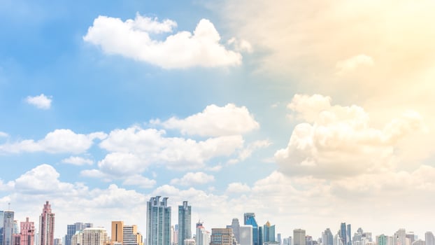 A city skyline with clouds and sun in the background photo