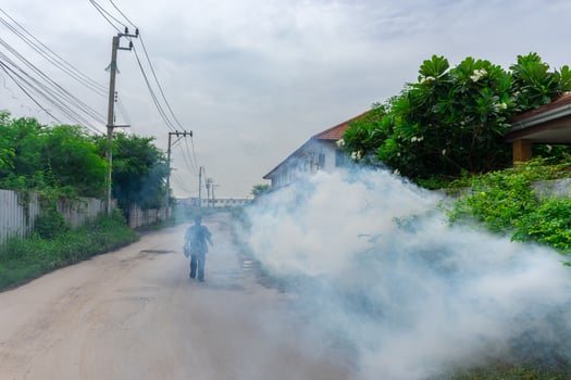 A man walking down a street with a large cloud of smoke photo