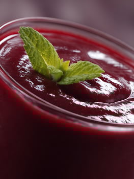 Close up of a Refreshing Red Smoothie Garnished with Mint. photo