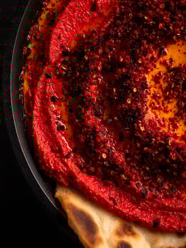 Close Up of Red Beet Hummus with Spices and Toasted Flatbread. photo
