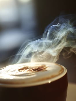 Close up of Steaming Cappuccino Coffee in a Dark Mug. photo