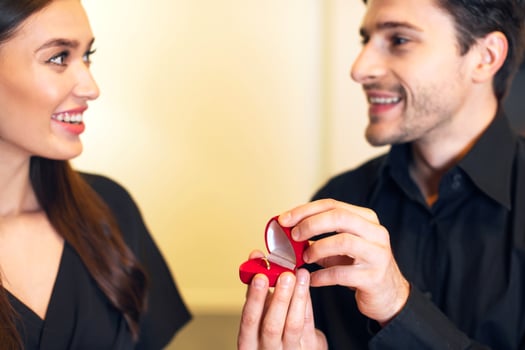 Will You Marry Me. Handsome bearded man holding and showing open box, offering marriage ring to his happy fiance, getting engaged during romantic date, closeup, selective focus on hands. Be My Wife photo