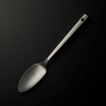 Single Silver Serving Spoon on Black Background with Studio Lighting photo