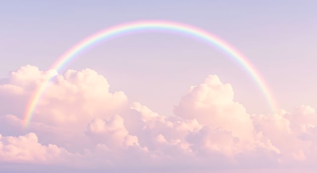 A rainbow is seen in the sky above clouds photo