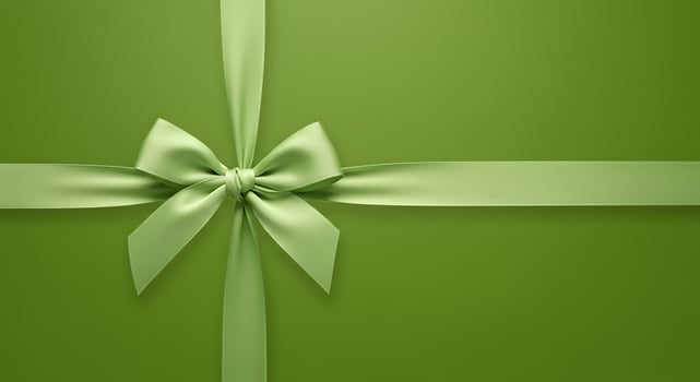 Green gift box with bow on a green background photo