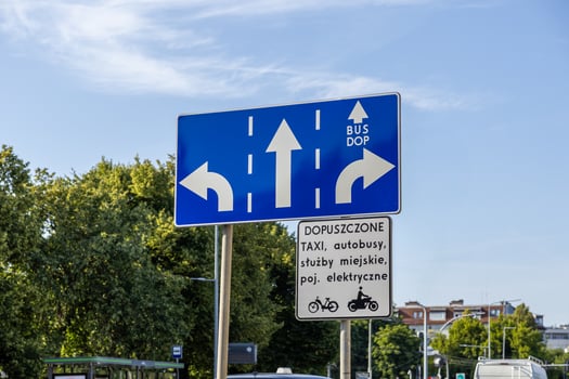 Blue urban traffic direction sign details multi-lane flow for cars, including a dedicated BUS DOP lane, managing authorized transportation and public services photo