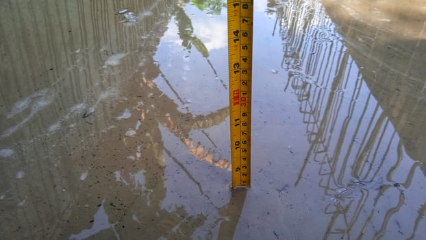 Measuring the water level in the channel using a measuring stick photo