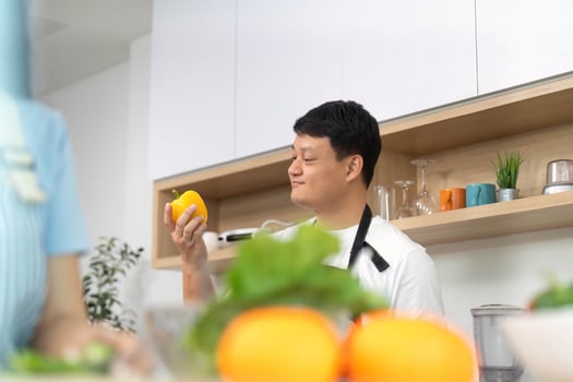 Healthy Lifestyle. Man Holding Fresh Yellow Bell Pepper in Kitchen photo