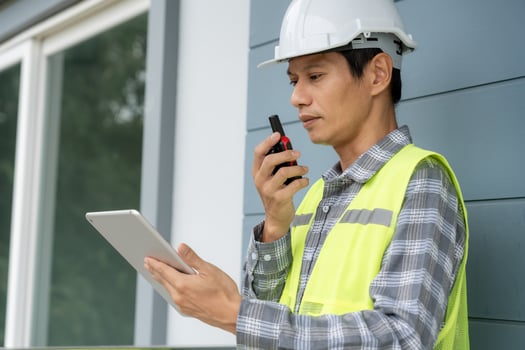 inspector, engineer is inspecting construction and quality assurance new house using a tablet. Engineers or architects or contactor work to build the house before handing it over to the homeowner photo