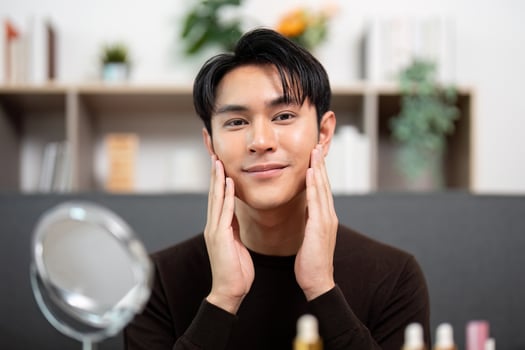 Self-Care. Man smiling after applying skincare products at home. photo