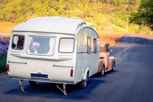 Retro classic caravan or recreational vehicle motor home trailer parked at parking area, vintage colour image. photo