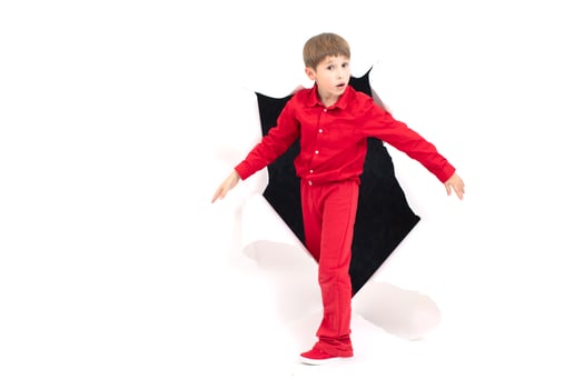 A child from a hole in paper. Boy shows cardboard. The concept of surprise and novelty photo