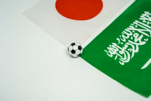 Football Rivalry Between Japan and Saudi Arabia with Flag Backdrop photo