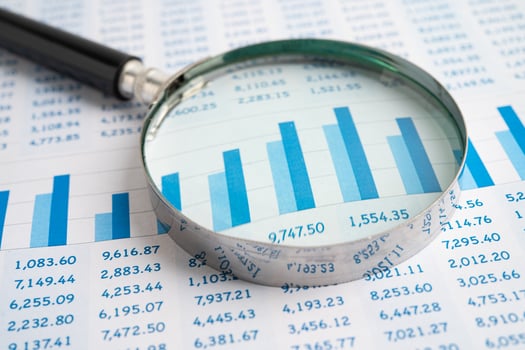 Magnifying glass on spreadsheet with graph photo
