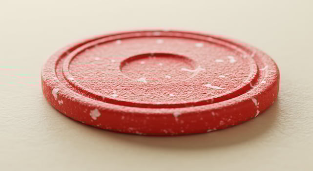 A red poker chip on a white surface photo