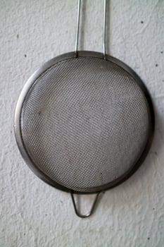 Round Metal Mesh Strainer Hanging on Wall photo