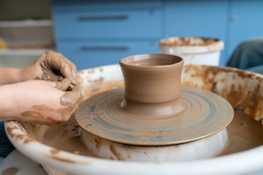 A person is making a pottery on a potter's wheel photo